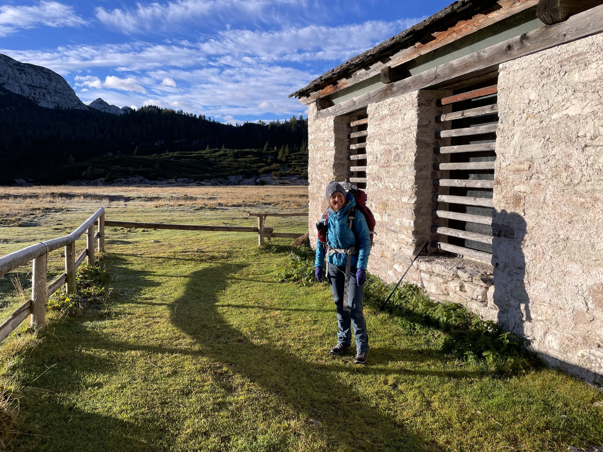 Elisa con lo zaino accanto a un edificio di montagna